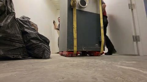 steel safe rolling on red machine skates down a hallway